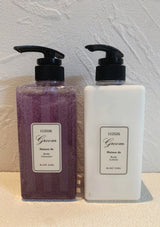 Two bottles of 'Green' body products on a textured surface with a neutral background.