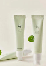 Two green skincare products with a white background