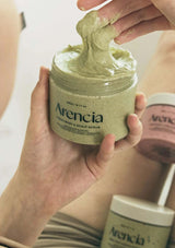 Person holding a jar of Arencia scrub with a close-up of the product.