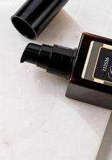 Perfume bottle with a gold cap on a light background