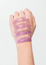 Hand wearing a pink silicone glove with multiple straps on a light gray background