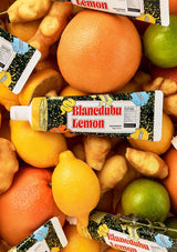 Fruit including oranges, lemons, and limes with Blanchedula Lemon toothpaste packaging.