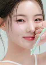 Woman applying pink makeup with a marker on a light background