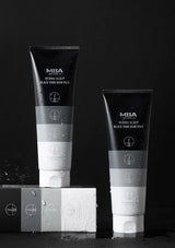 Two black and white tubes of MBA Derma Scalp Black Turn Hair Pack on a black background.