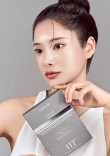 Woman holding a Mylvyan skincare product box against a gray background