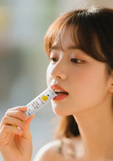 Woman using a lip balm with a blurred background