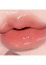Close-up of lips with a glossy lip color labeled '02 Fig Candy'.