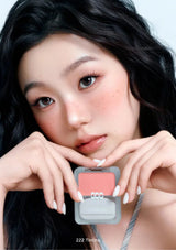 Woman holding a blush compact with a close-up of her face.
