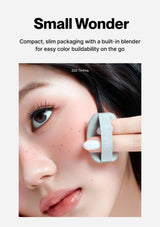 Compact makeup tool with a built-in blender being applied to skin, featuring text 'Small Wonder' and 'Z22 Tinting'.