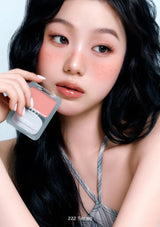 Woman holding a makeup product with a neutral background