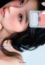 Close-up of a person with a cosmetic product labeled '222 Tinting' on a white background