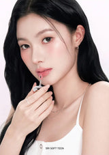 Woman applying lipstick with a neutral background