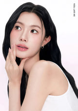 Woman with long black hair and a white top on a light pink background