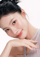 Woman with a soft smile, wearing a gray top on a white background