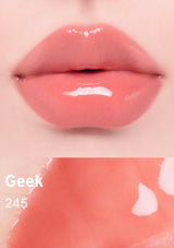 Close-up of glossy pink lips with 'Geek 245' text on a peach background