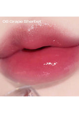 Close-up of a lip wearing a pink lip gloss with '06 Grape Sherbet' text.