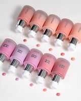 Pink and silver cosmetic bottles with visible brand name on a light background