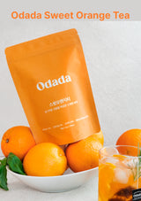Odada Sweet Orange Tea package with oranges and a glass of tea on a light background