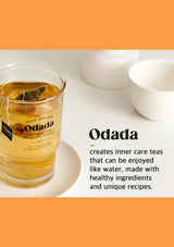 Glass of Odada tea with a tea bag on a white surface, surrounded by white bowls.