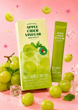 Green apple cider vinegar packets with grapes on a beige background