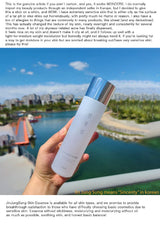 Hand holding a skincare bottle with a scenic background