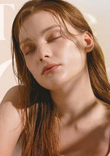 Close-up of a woman with long brown hair against a neutral background