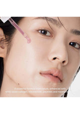 Close-up of a person applying a skincare product to their face with a dropper.