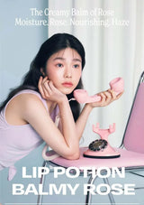 Woman holding a pink lip balm with text about 'The Creamy Balm of Rose' and 'Lip Potion Balmy Rose'.