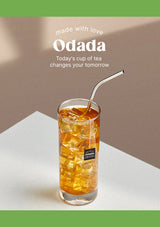 Glass of iced tea with a metal straw on a white surface, featuring the Odada brand.