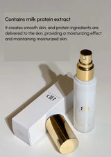 White skincare bottle with gold accents and packaging on a light gray background