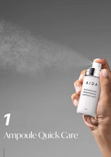 Hand holding a bottle of AIDA Ampoule Quick Care mist against a gray background
