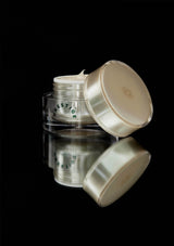 Three cosmetic jars with white lids on a black background