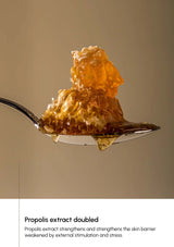 Spoon with honeycomb filled with propolis extract on a beige background