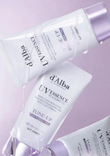 d'Alba UV Essence watermelon skincare products on a light purple background