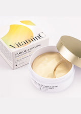 A box of K-Secret Extra Illuminating Eye Gel Patches with Vitamin C, showing the product name and patches in yellow color with a golden spatula.