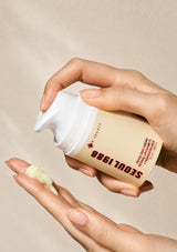Hand holding a cream container labeled 'Soul 1988' with a beige background