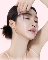 Woman receiving a dermal filler injection on her face with a pink background