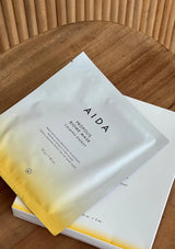 AIDA beauty mask packaging on a wooden surface