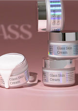 Multiple jars of Glass Skin Cream on a pink background