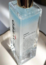 Clear bottle with gold cap labeled 'PinkGhost' on a reflective surface