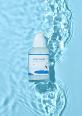 Skincare bottle with water droplet on a blue water background