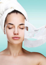 Woman with a towel on her head against a light blue background