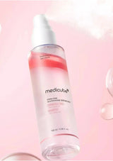Medicube serum bottle on a pink background