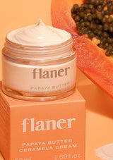 Jar of flaner papaya butter cream with a papaya fruit on an orange background