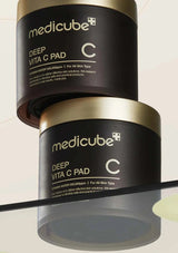 Two containers of Medicube Deep Vita C Pad on a beige background