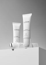 Three white tubes of Lagom skincare products on a gray background