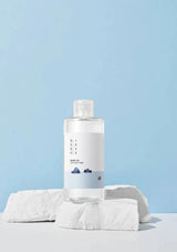 Skincare bottle with towel on a light blue background