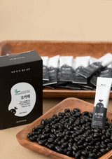 Black beans on a wooden tray with packaging and products in the background