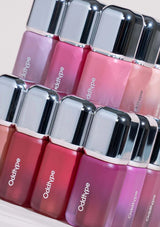 Row of Oddtype nail polish bottles with pink and red shades.