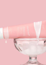 Pink skincare product with a glass container on a pink background